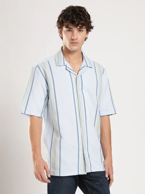 A man in a sky-blue striped camp-collar shirt